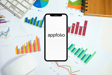 A phone that says “appfolio” next to graphs on desk.